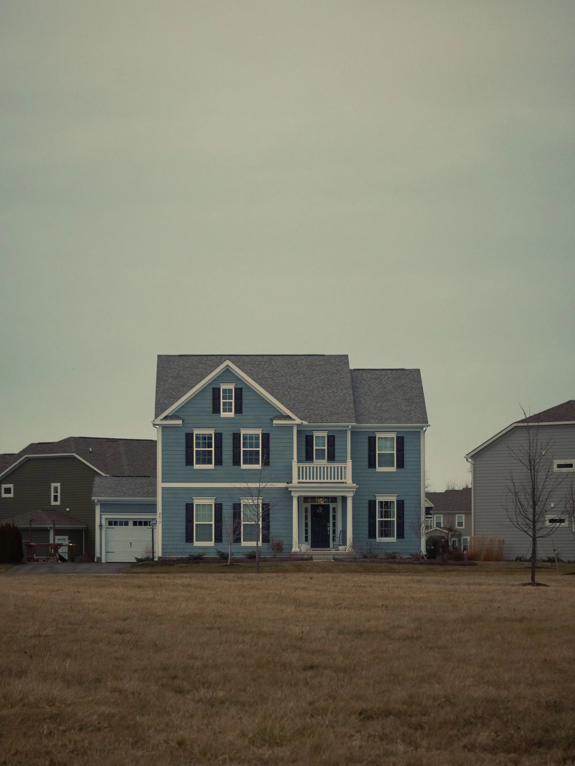 A blue clapboard house with a grey shingle roof