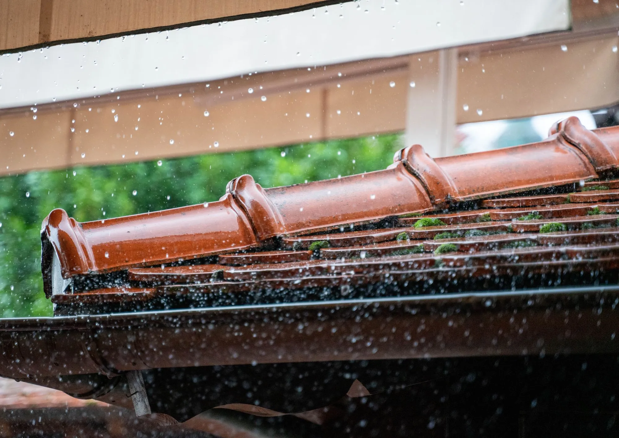 Rain running off a roof edge into the gutter below