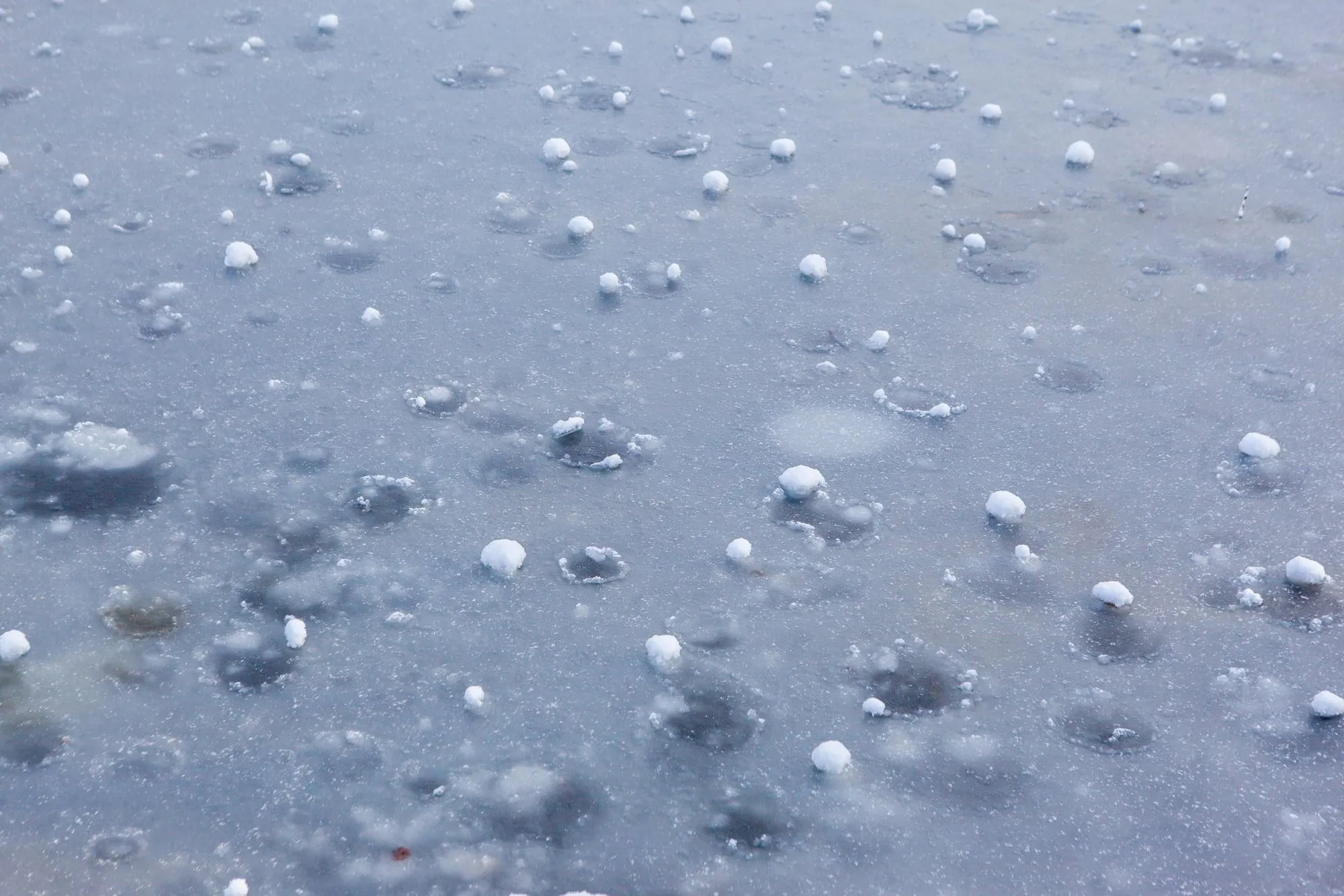 Hailstones scattered across a surface after a storm